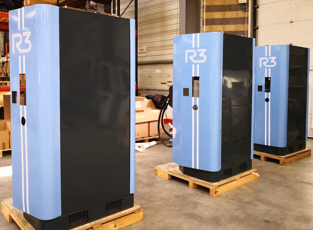 Application d'un film adhésif polymère bleu avec logo blanc R3 sur une borne de recharge électrique par DM Création.