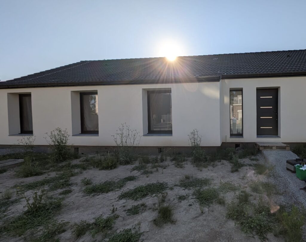 Façade d'une maison moderne avec des fenêtres classiques avant la pose de films solaires pour vitrage.