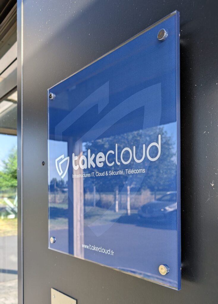 Plaque professionnelle en plexiglas imprimée avec logo et coordonnées pour Takecloud par DM Création.